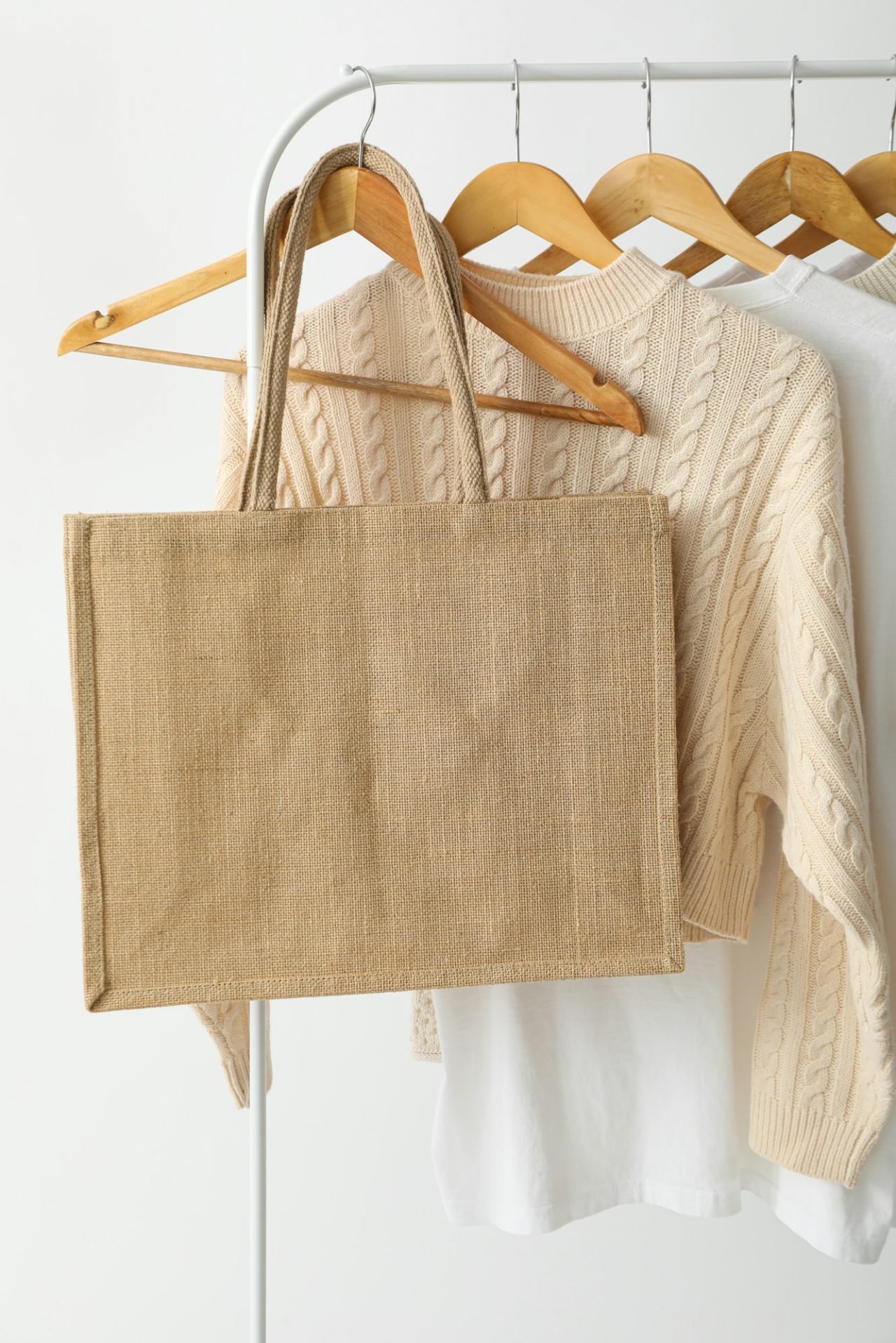 A bag hangs on a hanger with clothes