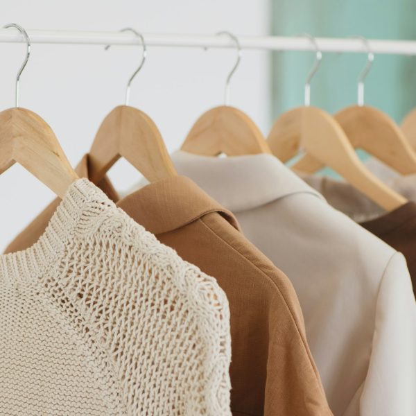Closeup photo of hangers in clothing rack.
